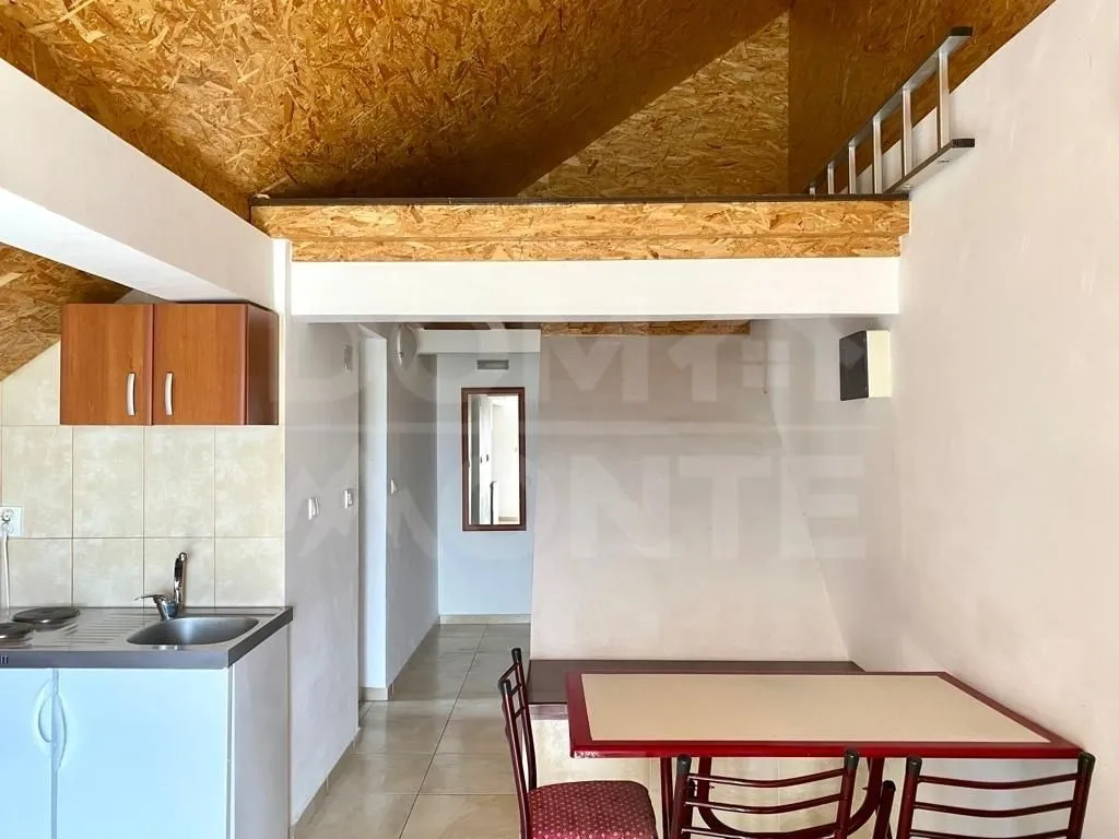 Smaller kitchen with a dining table and a loft gallery.