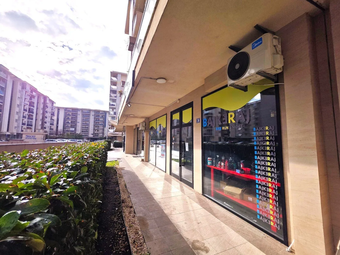 Exterior of the commercial space with a shop window and a walkway in front.