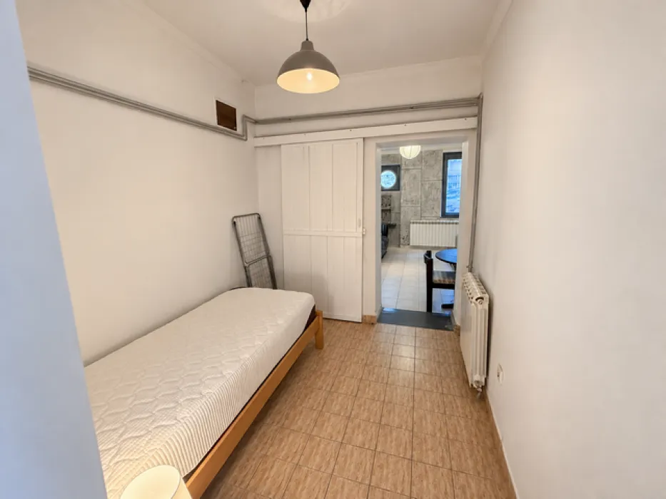 Small bedroom with a bed and a radiator.