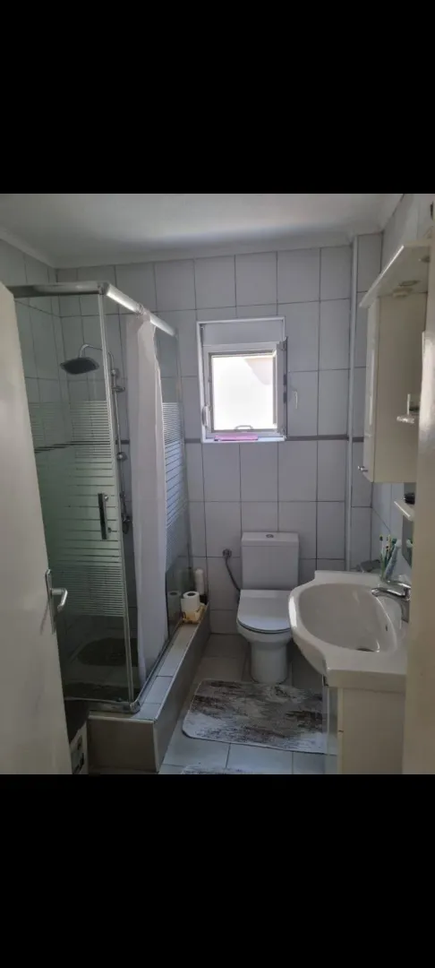 A functional bathroom with a shower cabin and a window.