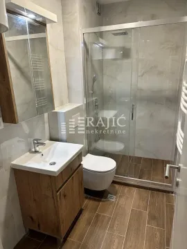 Modernly equipped bathroom with a shower cabin and a sink. - image 7