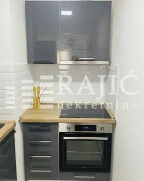 Small kitchen with grey cabinets and a built-in oven. - image 15