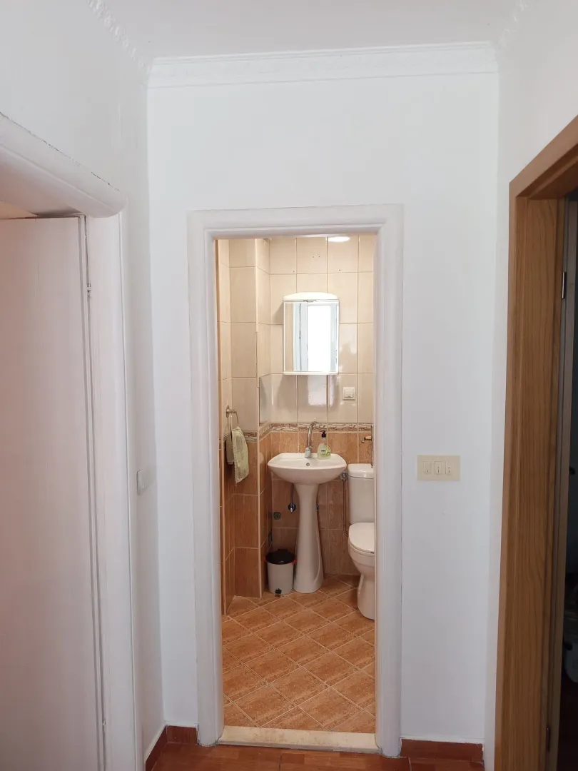 View from the hallway into a small bathroom with a sink and toilet.