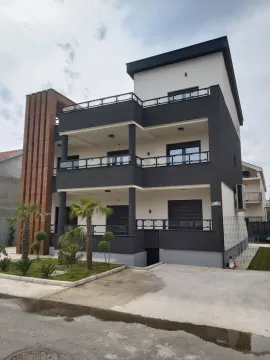 Modern residential building featuring a dark grey and white facade with landscaped yard. - image 8