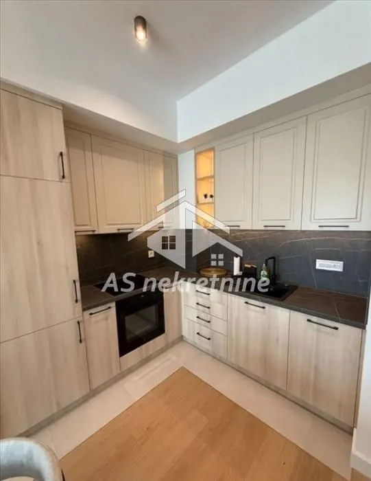 Modern kitchen with wooden cabinets and a built-in oven.