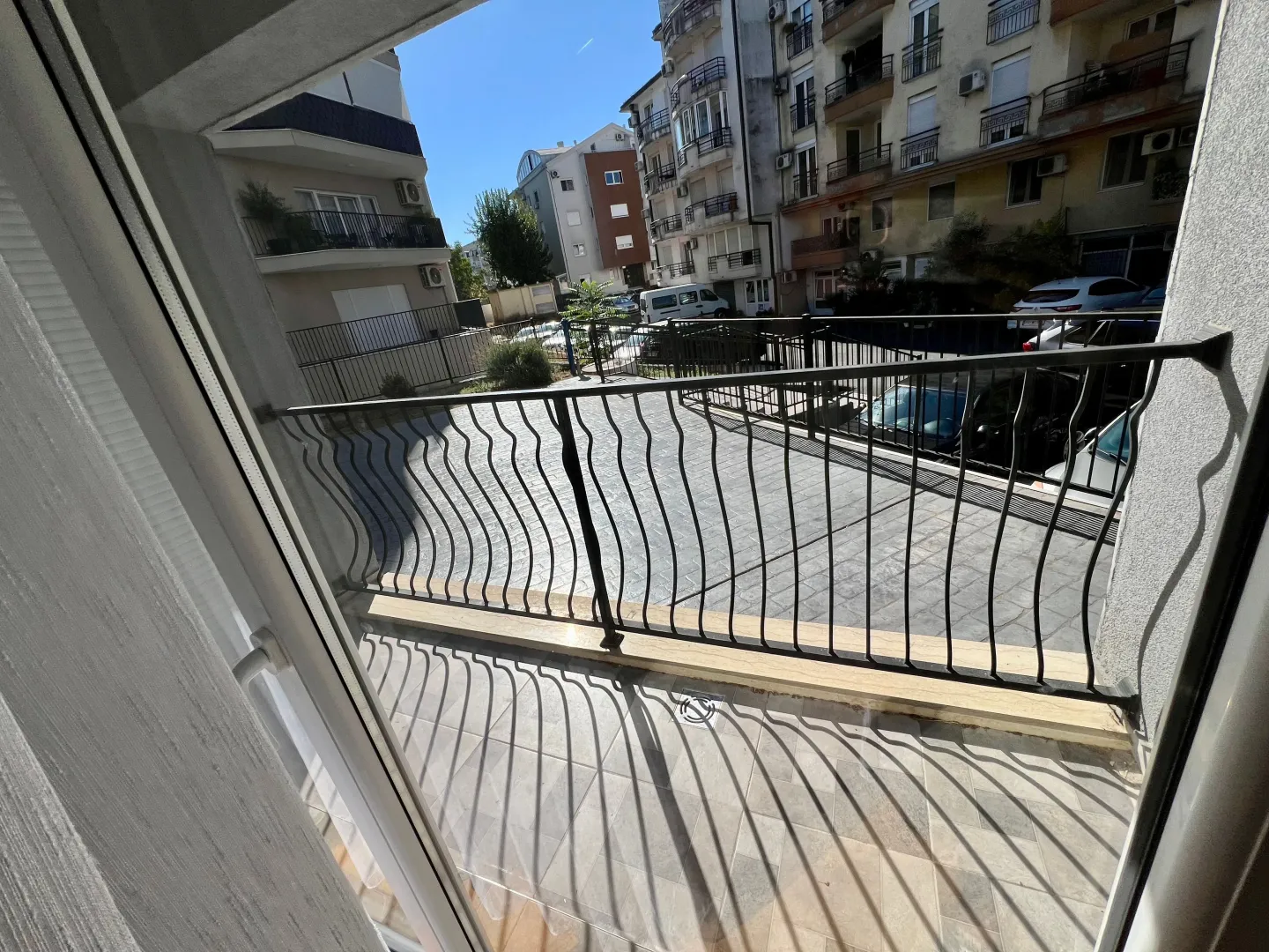 Pogled sa balkona na dvorište i okolne zgrade.