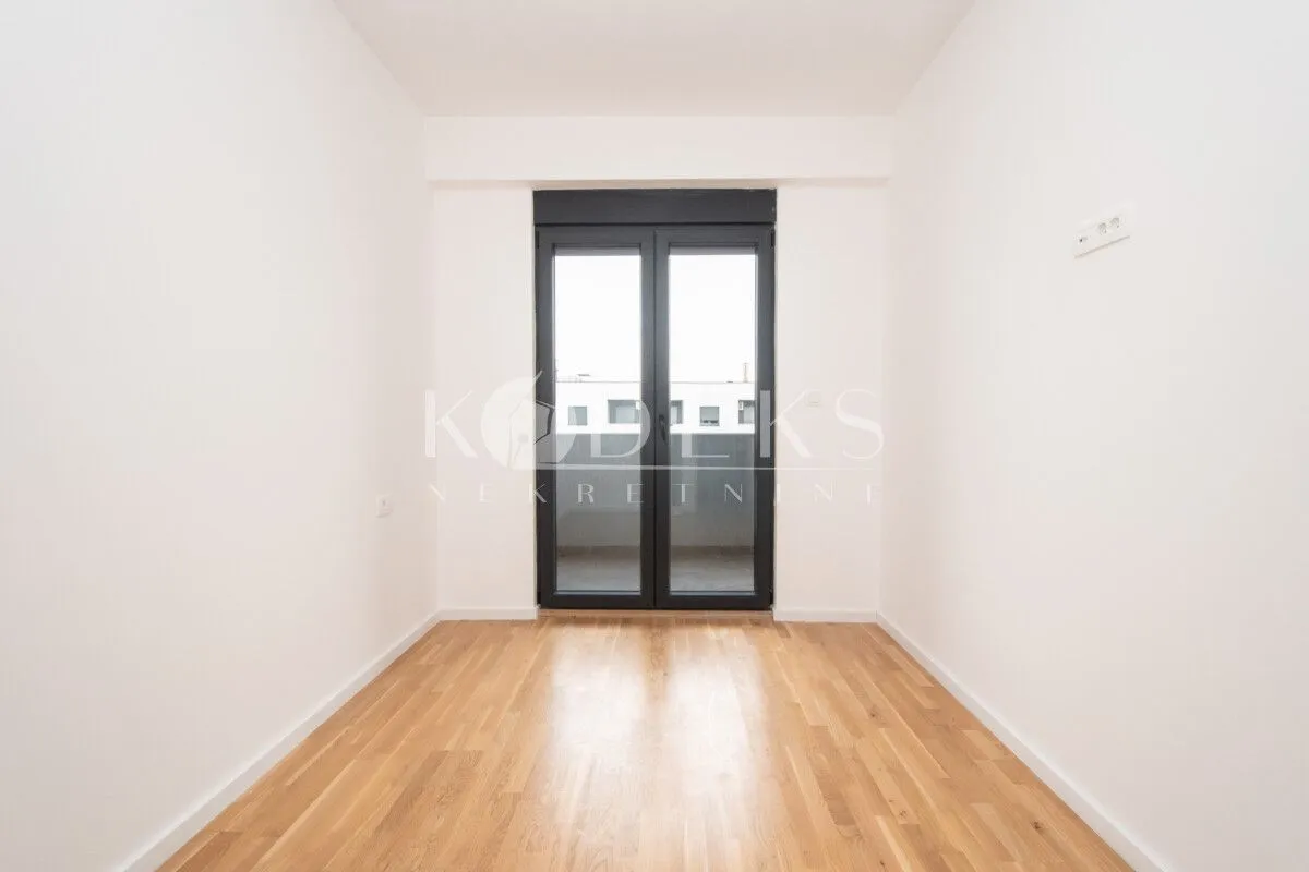 Empty room with parquet flooring and access to the terrace.