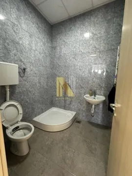 Smaller bathroom with a shower cabin, washbasin, and toilet bowl tiled with ceramic tiles. - image 9