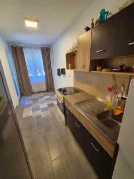 Small kitchen with a sink, stove and wall cabinets. - image 6