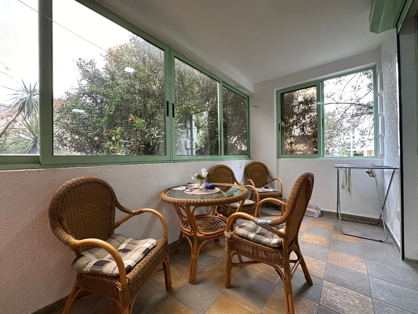 Enclosed terrace with rattan seating furniture.