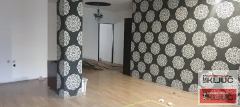Empty living room with patterned wallpaper on the walls and laminate flooring. - image 4