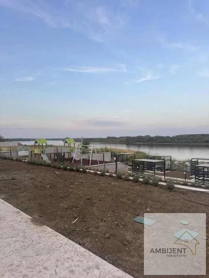 Dvorište sa igralištem i pogledom na reku.