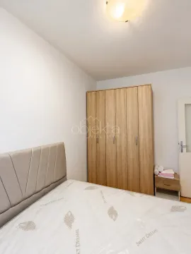 Spavaća soba sa bračnim krevetom i drvenim ormarom. - image 4