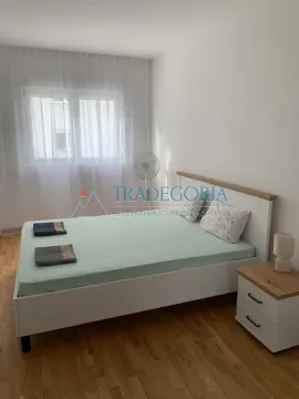 Spavaća soba sa bračnim krevetom, noćnim stočićem i prozorom sa zavjesama. - image 6