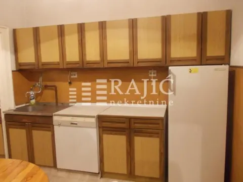 Smaller kitchen with wooden units and a refrigerator. - image 13