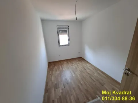 Prazna soba sa belim zidovima i drvenim parketom. - image 4