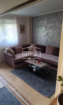 Living room with a sectional sofa and a coffee table. - image 9