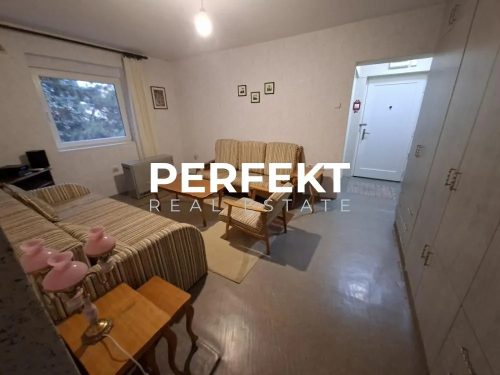 Dnevna soba sa garniturom za sedenje i prozorom.