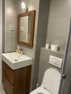 Moderno kupatilo sa drvenim namještajem, umivaonikom i ogledalom. - image 4
