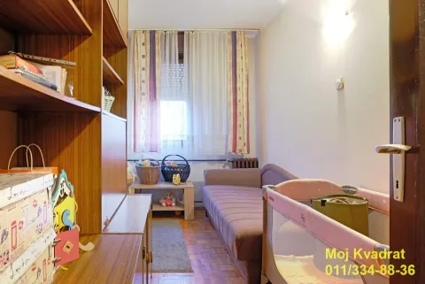 Manja spavaća soba sa krevetom, krevetcem i drvenim ormarima. - image 7