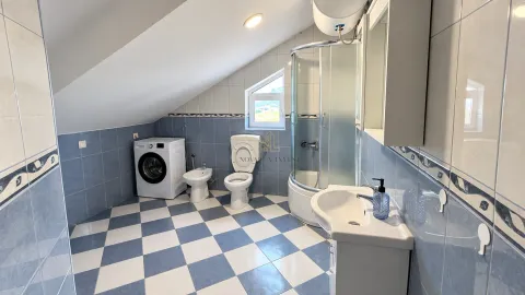 Attic bathroom with a shower cabin, washbasin, toilet, bidet, and washing machine. - image 4
