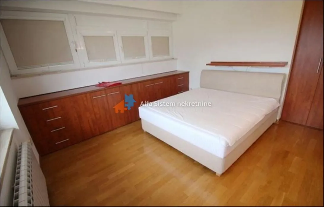 Bedroom with a double bed, wooden floor and built-in closets.