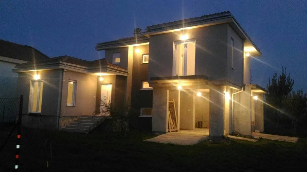 View of the illuminated facade of the house at night.