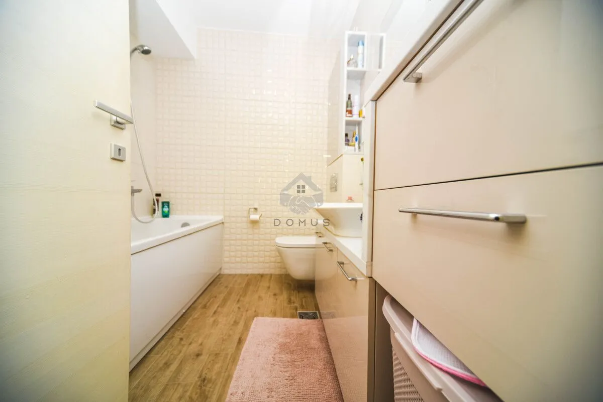 Smaller bathroom with a bathtub, washbasin, and toilet.