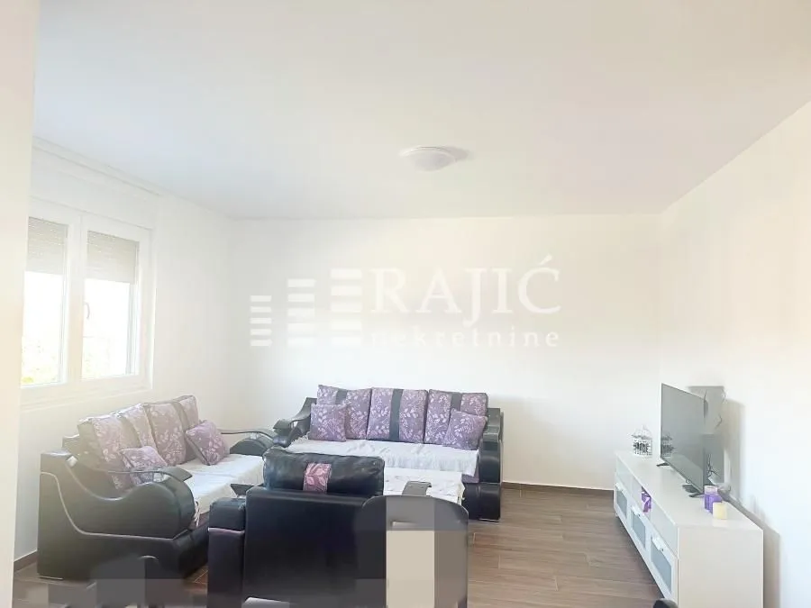 Living room with sofa set and TV.