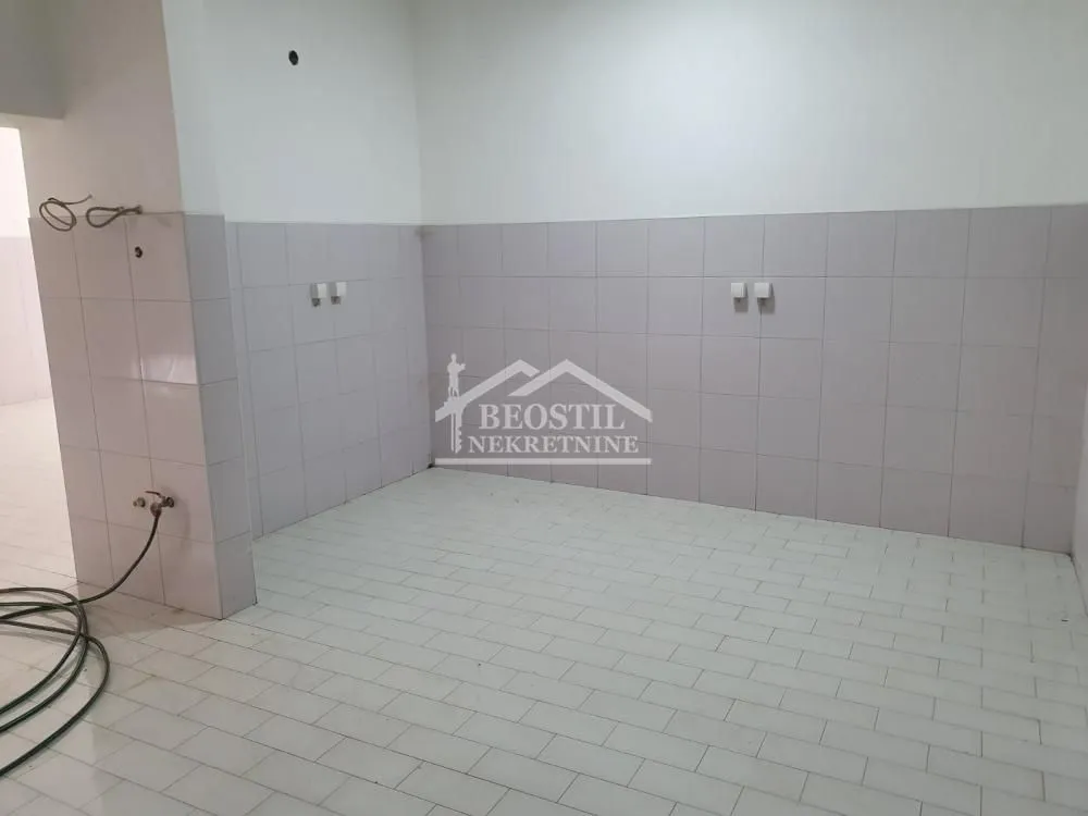 Empty room with tiles on the walls and floor, suitable for kitchen installation.