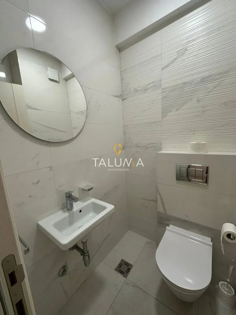 Moderne kupatilo sa umivaonikom, ogledalom i wc šoljom.