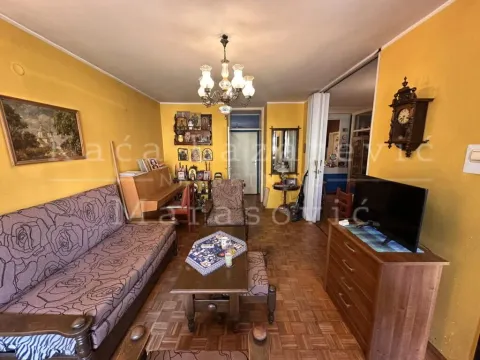 Dnevna soba sa garniturom za sedenje, televizorom i parketom na podu. - image 6