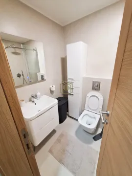 Modernly equipped bathroom with a washbasin, toilet, and walk-in shower. - image 9