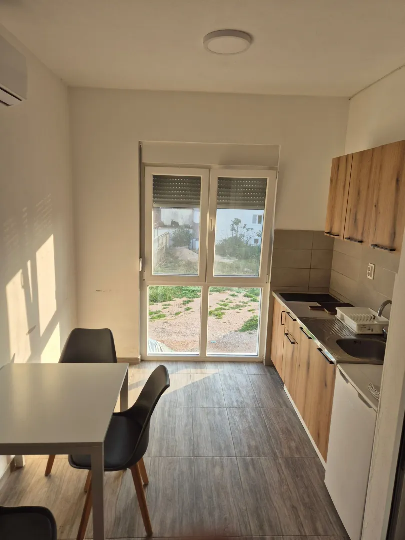 Smaller kitchen with a dining table and access to the yard.