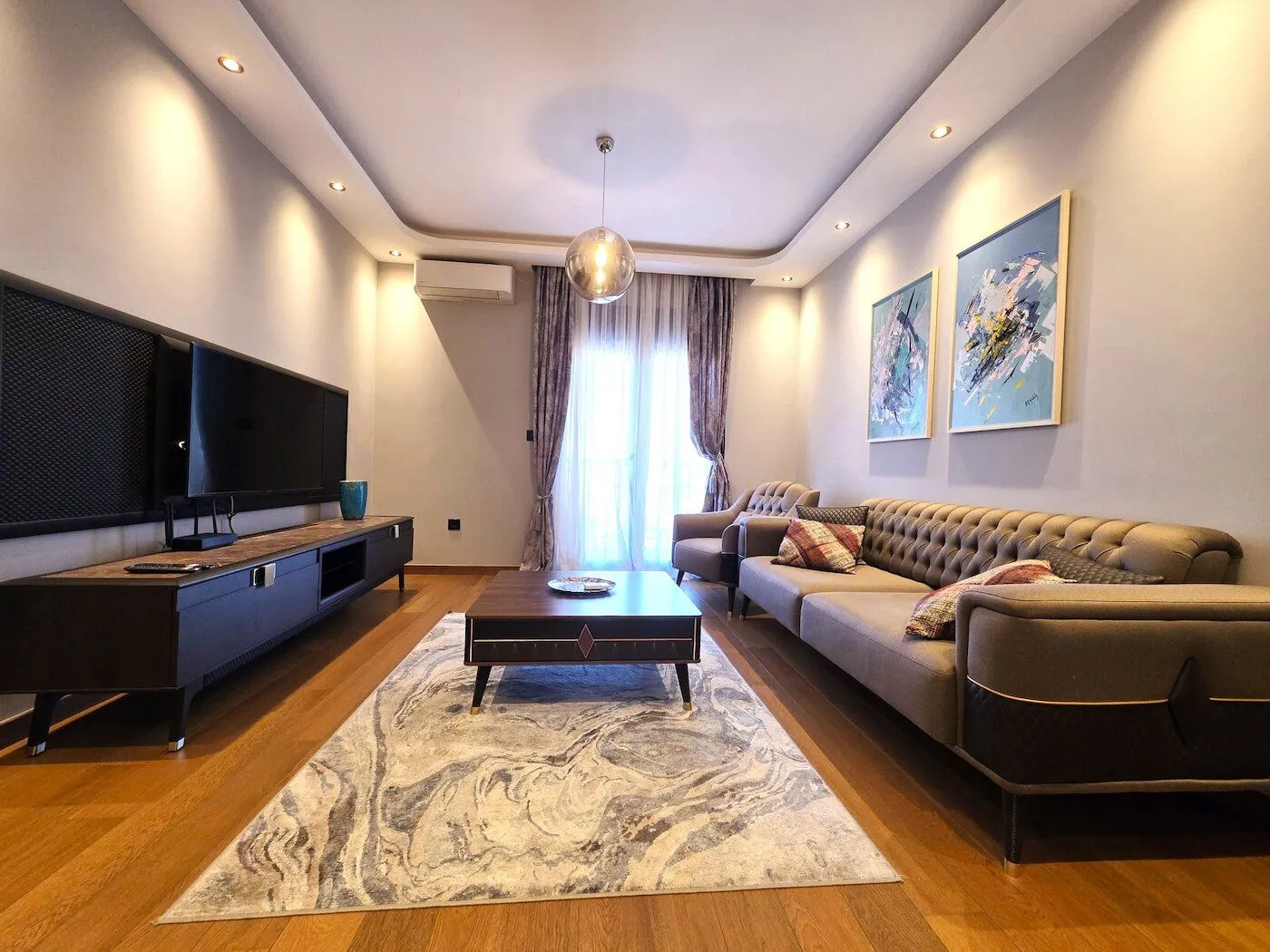 Modern and tidy living room with a sofa set, television, and coffee table.