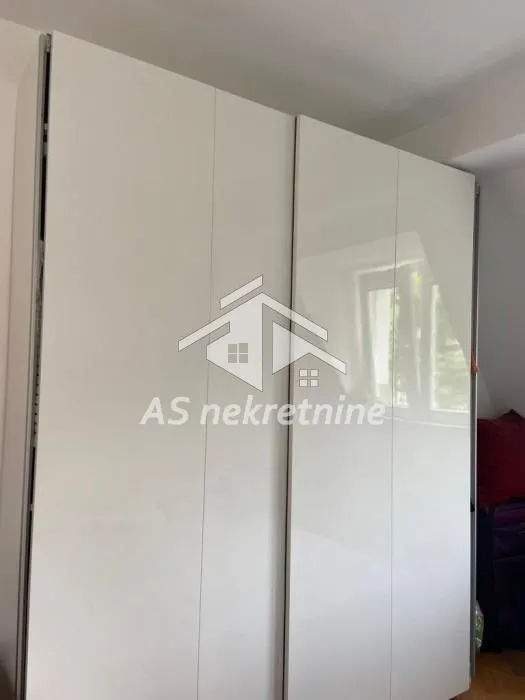 Veliki beli ugradni ormar sa kliznim vratima u spavaćoj sobi.