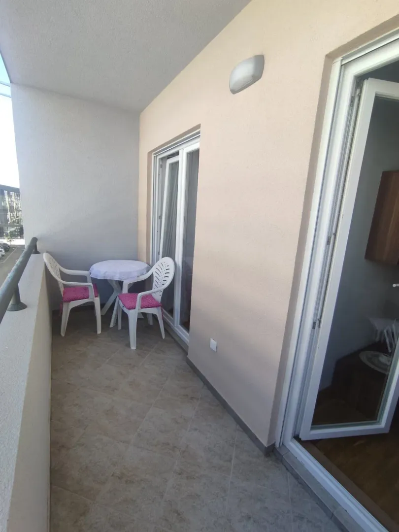 A balcony with a small table and two chairs.