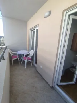 A balcony with a small table and two chairs. - image 3