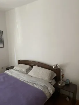 A simple bedroom with a double bed and nightstands. - image 2