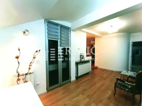 Living room with wooden flooring, balcony doors, and a passageway to another room. - image 4
