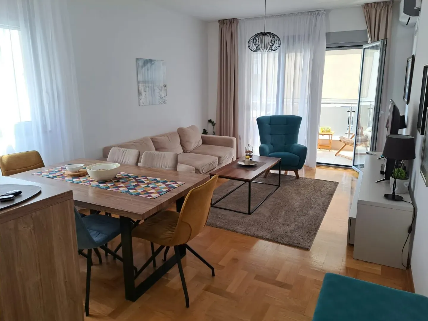 Svijetao dnevni boravak sa trpezarijom i izlazom na balkon.