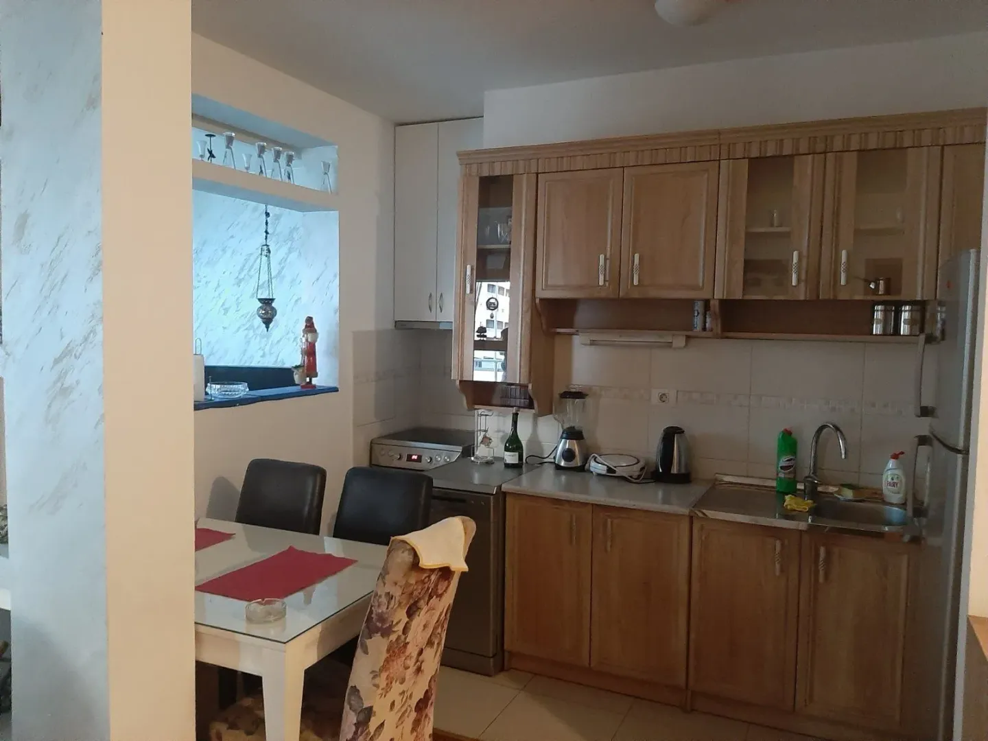 Kitchen with wooden cabinets and dining table.