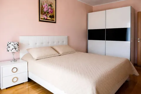 Furnished bedroom with a double bed, white wardrobe, and a nightstand. - image 6