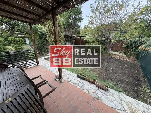 Covered terrace with a table and chairs overlooking the yard.