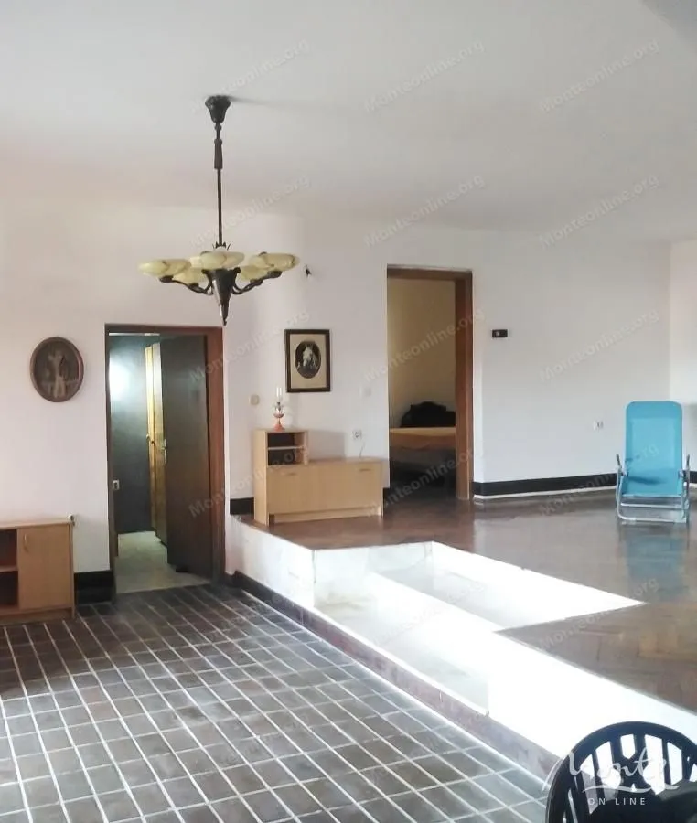 Spacious living room with a tiered floor and a chandelier.
