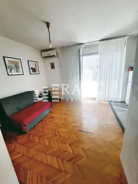 Living room with parquet flooring and a sofa. - image 4