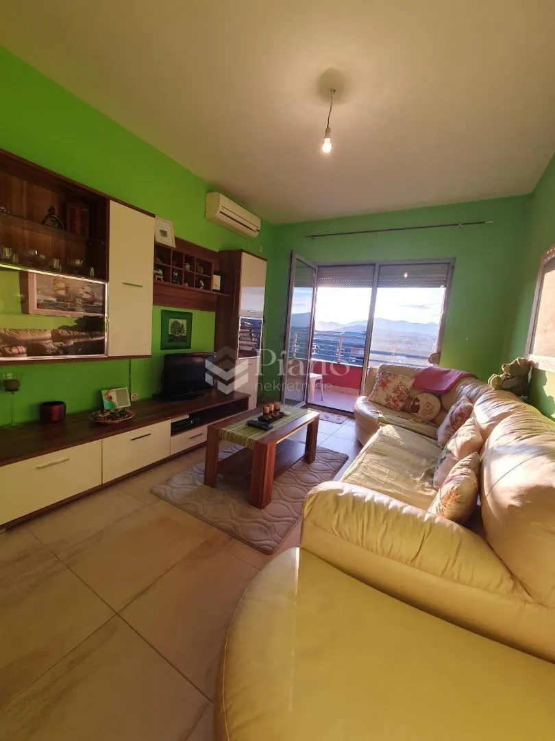 Living room with a sofa set, TV unit, and access to the terrace.
