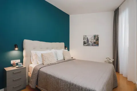 Furnished bedroom with a double bed and a blue accent wall. - image 14