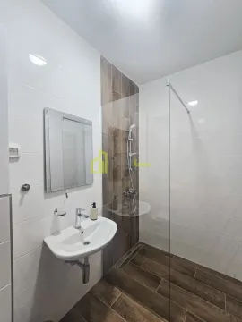 Moderne kupatilo sa umivaonikom, ogledalom i tuš kabinom sa staklenom pregradom. - image 10