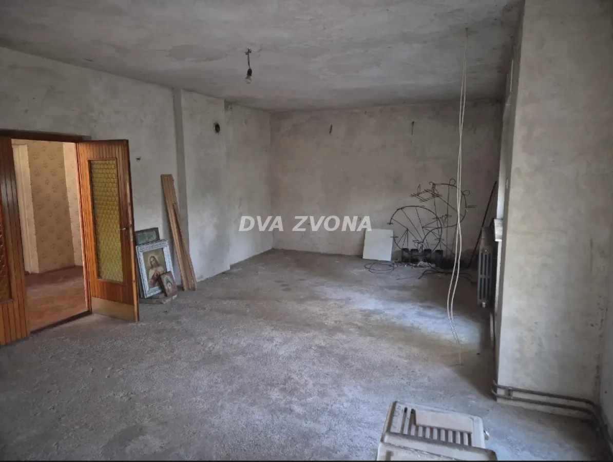 Prazna prostorija u izvornom stanju sa drvenim vratima.